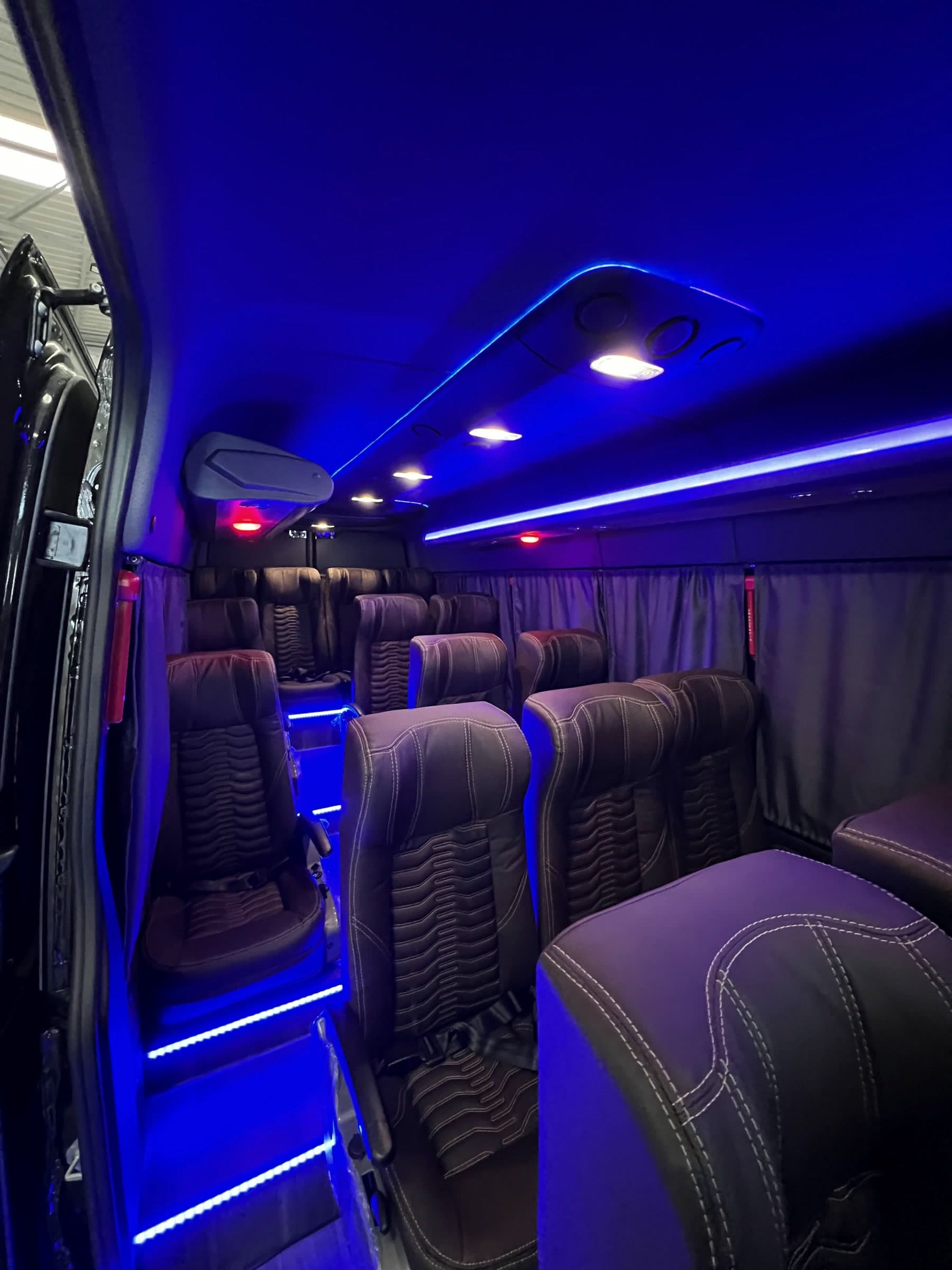 Interior da van Sprinter da JRW com poltronas de couro e luz azul